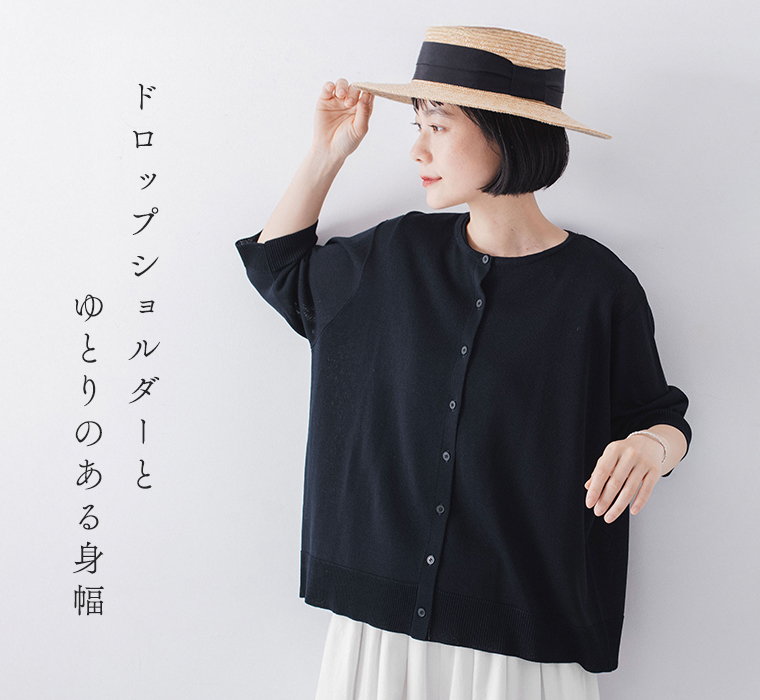 5分袖ニットカーディガン ネイビーを着たモデルが横を向いて帽子に手を添えている