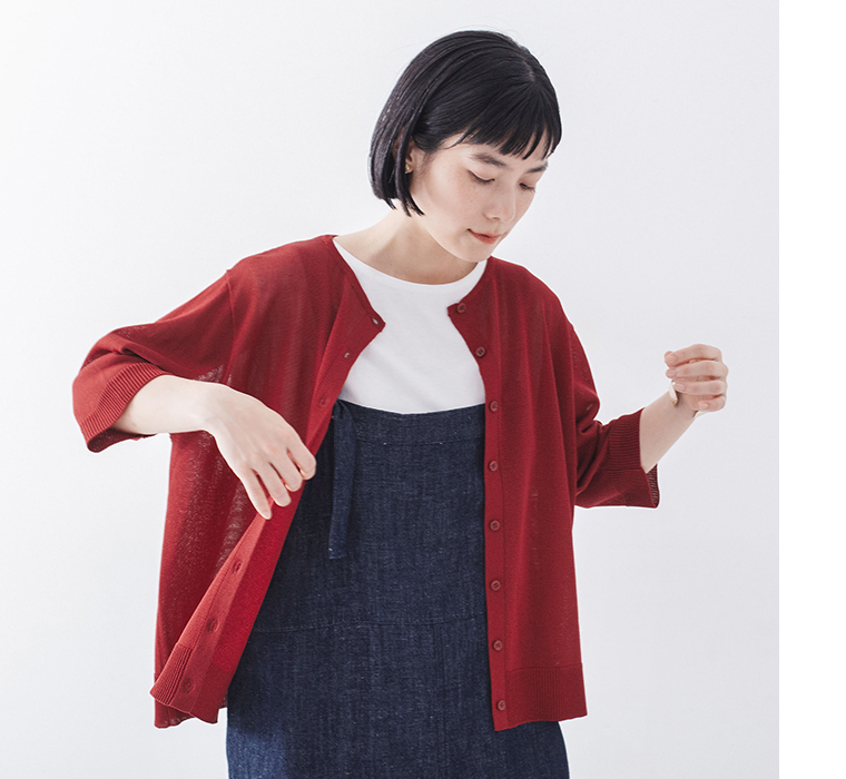 5分袖ニットカーディガン レッドを着たモデルが前を見て腕を曲げている