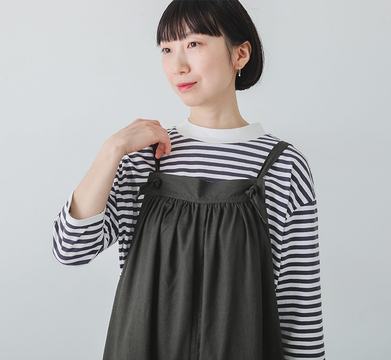 ごきげんになれるサロペットの肩紐部分を持っている上半身