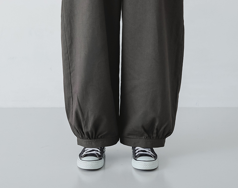 ごきげんになれるサロペットの裾のギャザーとスニーカーの足元