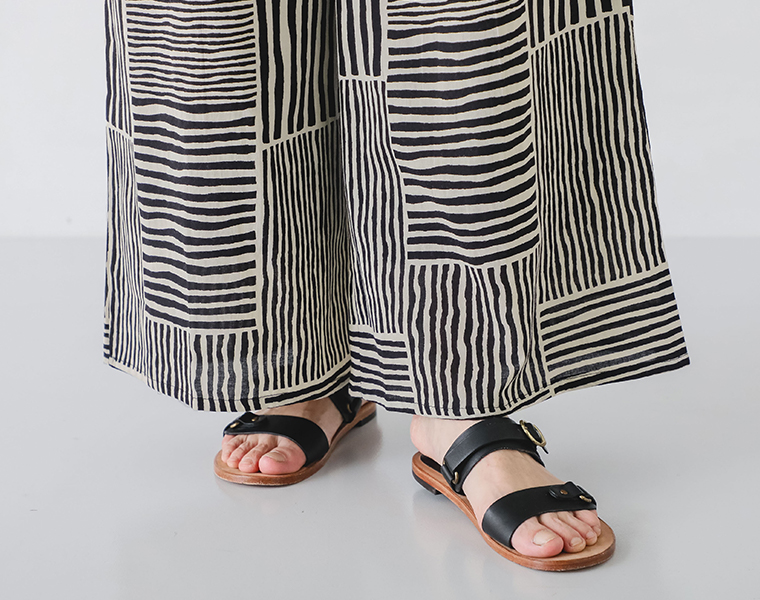 ストライプパンツの裾とサンダルの足元