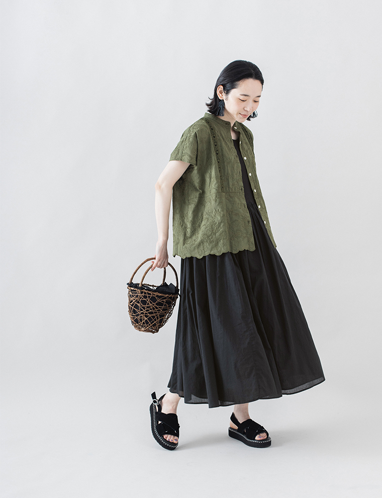カーキの半袖羽織を黒のロングワンピースに重ねた全身コーディネート画像（かごバッグと厚底サンダルを合わせたスタイル）