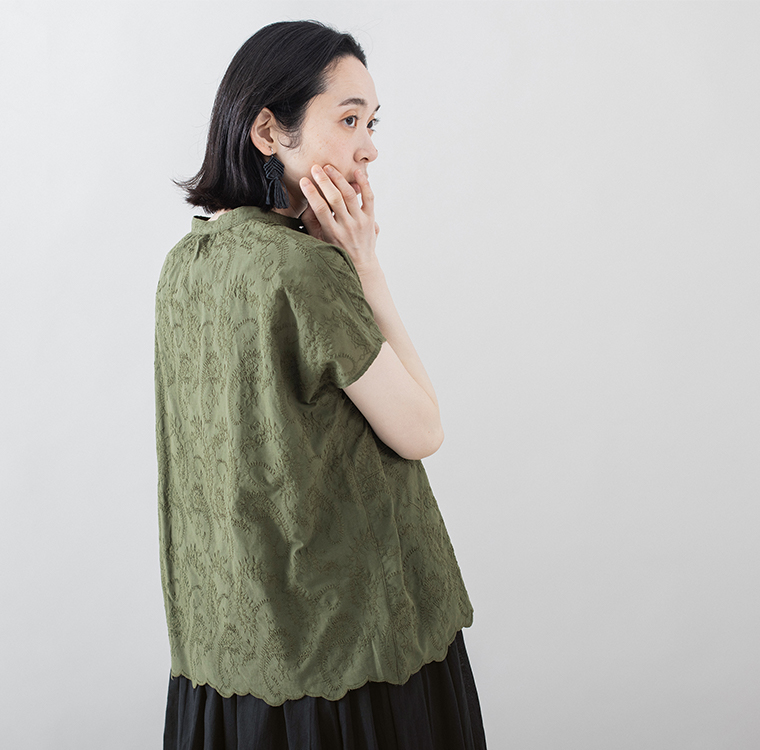 カーキの刺しゅうブラウスを着た人物の横向きカット（スカラップ裾と立体的な刺しゅうが見える）