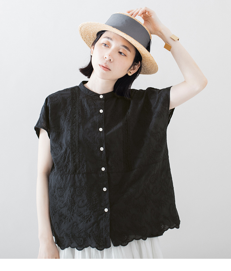 黒の刺しゅうトップスを着た人物の上半身カット（前立てのレースディテールとスカラップ裾が見える）