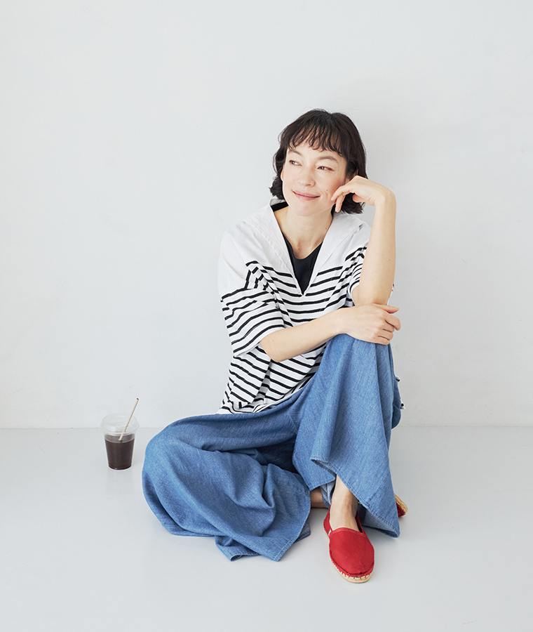ブルーの甘撚ライトデニム フレアパンツを着用したモデルの座り画像
