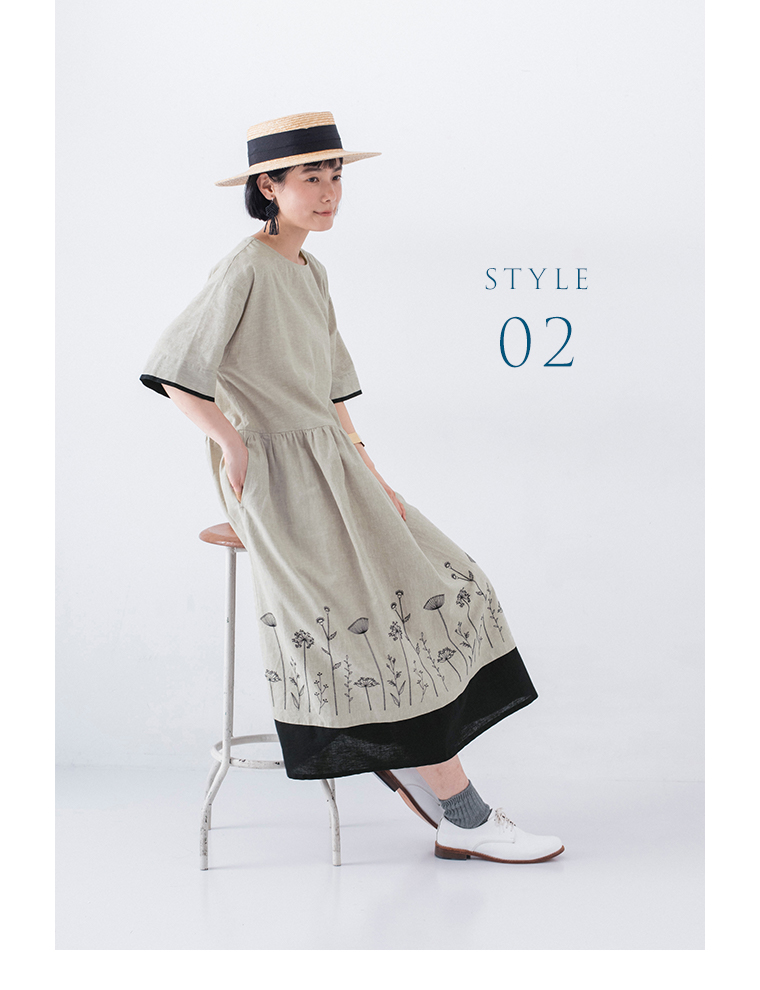 配色切替え刺繍ワンピースを着た人物の横向き着席カット（「STYLE 02」の文字入り）。