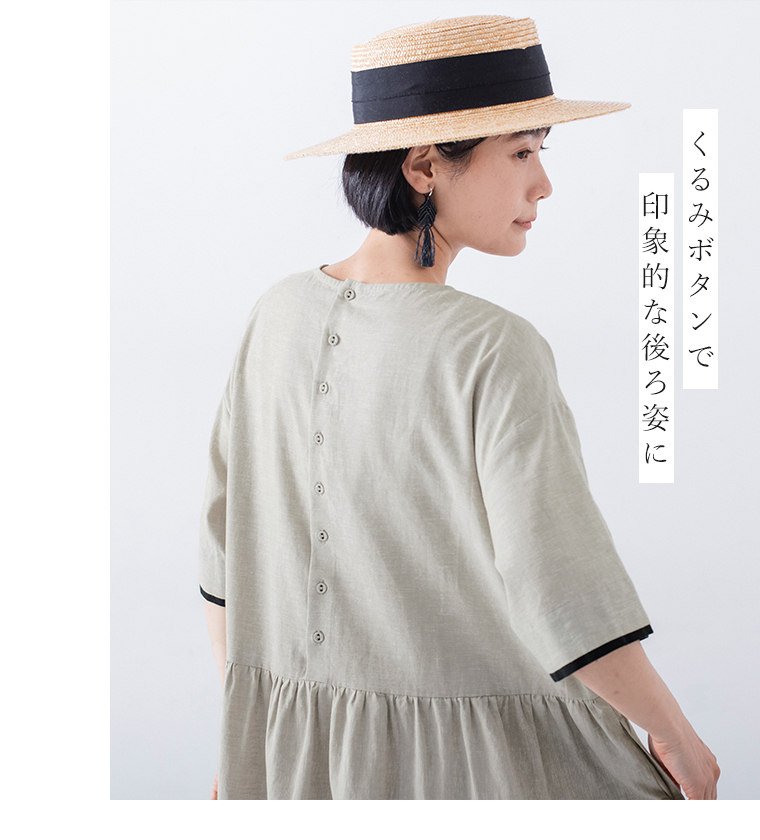 配色切替えワンピースのバックボタンが見える後ろ姿カット（「くるみボタンで 印象的な後ろ姿に」の文字入り）。