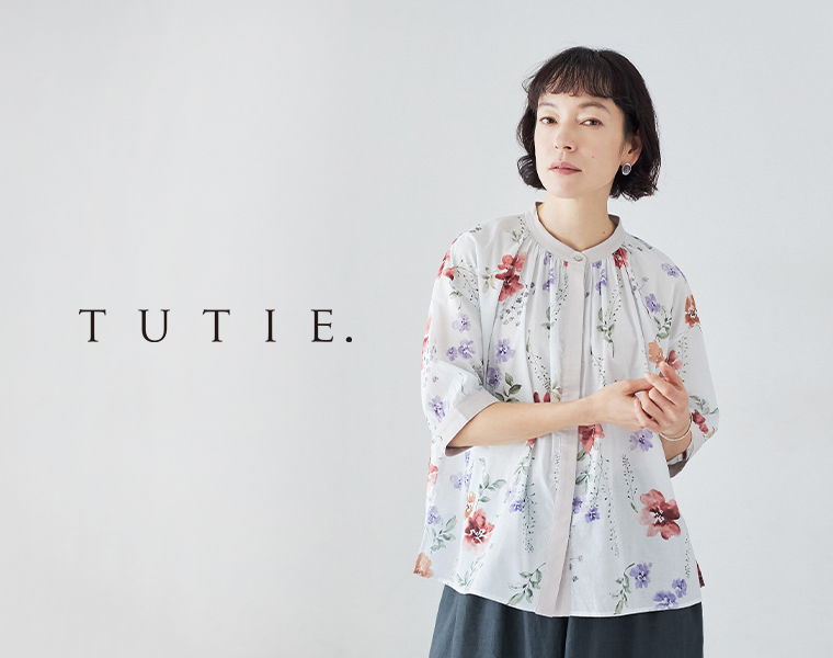TUTIE. コットンボイル フラワープリントブラウスを着用した女性モデルの上半身スタイル
