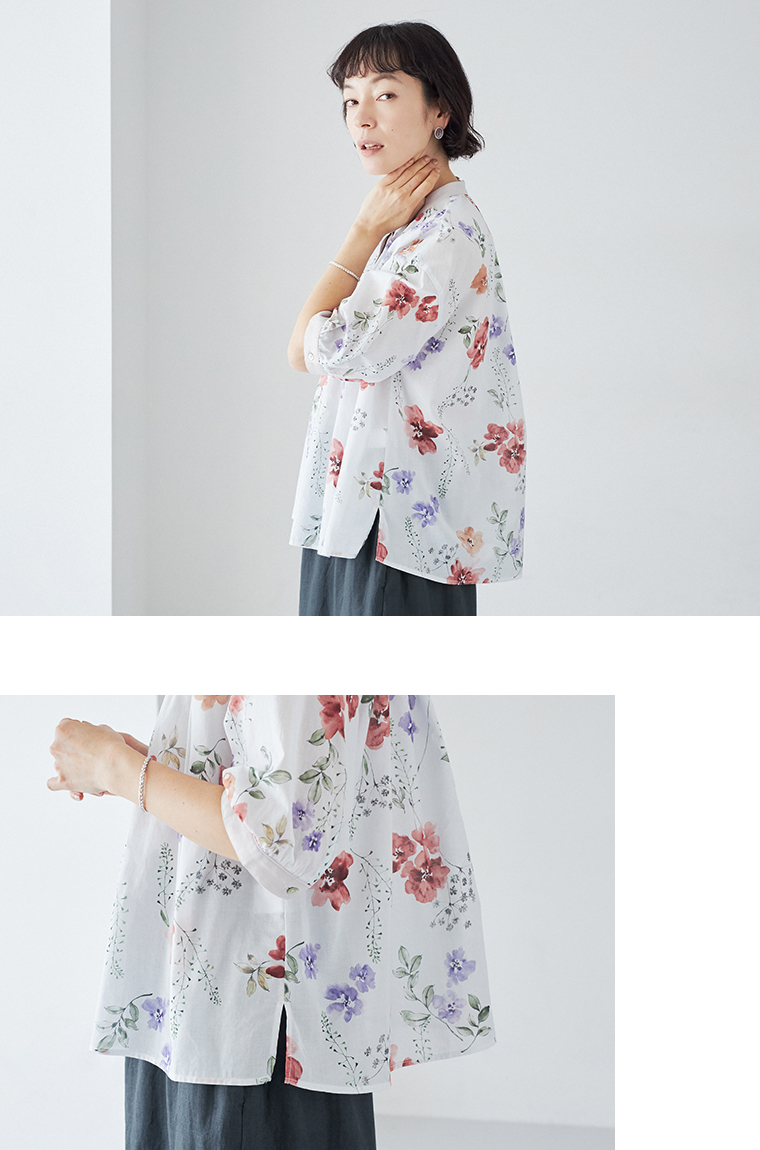 レッドの花柄ブラウスの裾サイドスリットを見せた着用画像