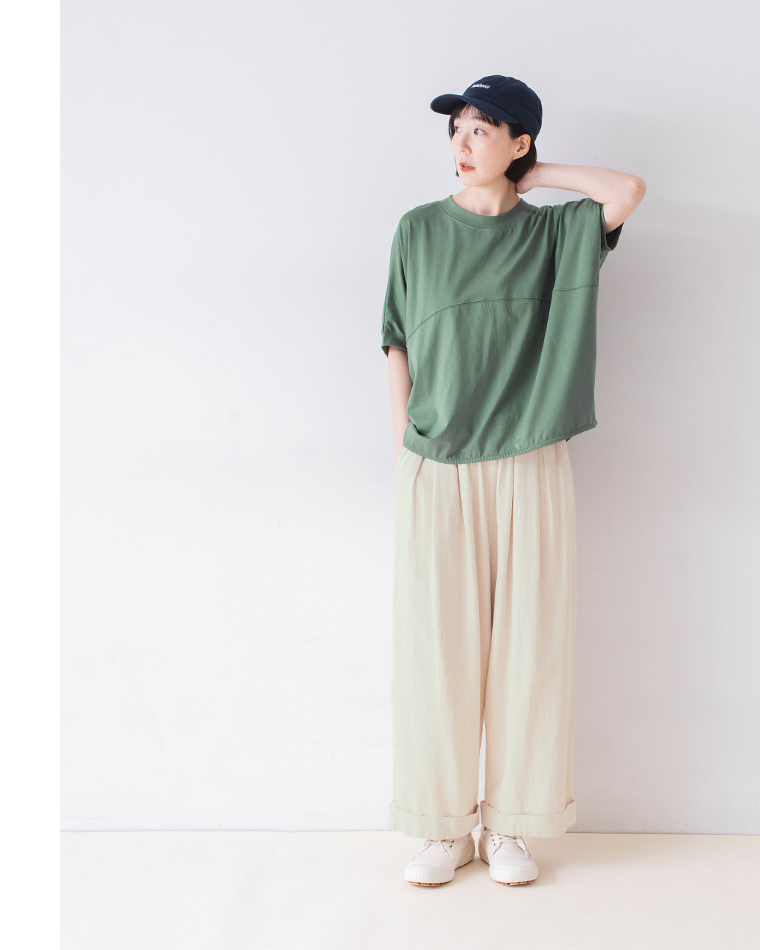 &yarn ポンチョプルオーバー（グリーン）を着用した人物の正面コーディネート — ベージュのワイドパンツとキャップを合わせたナチュラルなスタイリング
