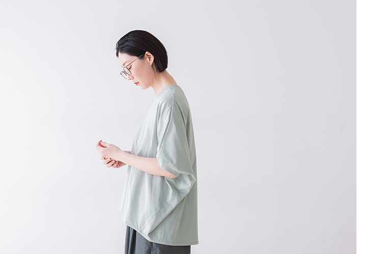 &yarn ポンチョプルオーバー（ライトグレー）を着用した人物の横向きカット — ゆったりとしたシルエットと柔らかなドレープ感が特徴