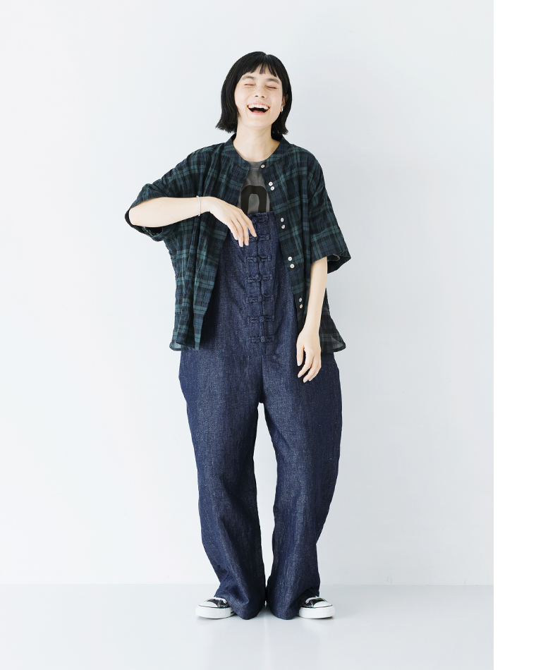 Dgy コットンリネンデニムチャイナボタンサロペットのコーディネート（ロゴTシャツにチェックシャツを羽織ったカジュアルスタイル。リラックス感のある着こなしで笑顔の人物）