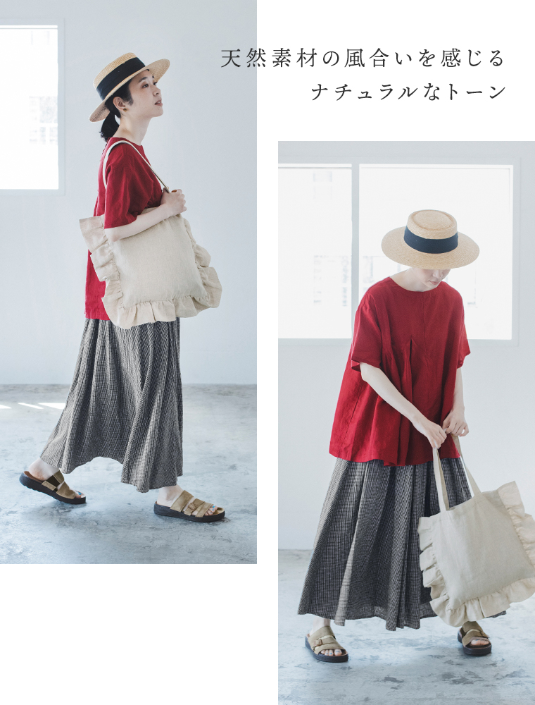 08Mabの リネンフリルトートバッグ（キナリ）を肩に掛けた女性のコーディネート画像。赤のトップスにチェック柄のロングスカート、麦わら帽子とサンダルを合わせたナチュラルスタイル。画像内テキスト「天然素材の風合いを感じる ナチュラルなトーン」。