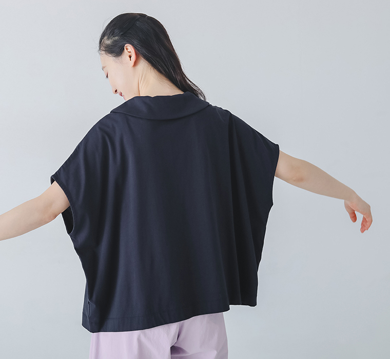 並びボタン襟つきトップスを着用したモデルの後ろ姿画像