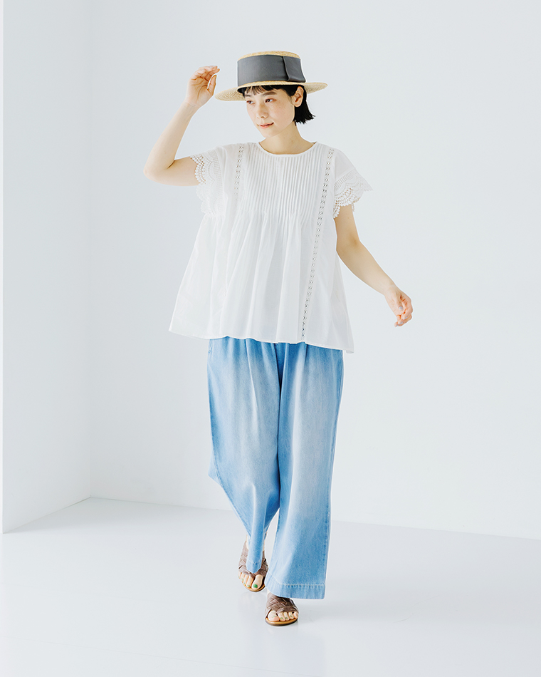 Lintu Lauluレースピンタックブラウス（ホワイト）の着用コーディネート画像。繊細なピンタックとスカラップレース袖が特徴のブラウスに、ライトブルーのワイドデニムパンツを合わせた爽やかなスタイリング。麦わら帽子とサンダルで軽やかな夏の印象に。