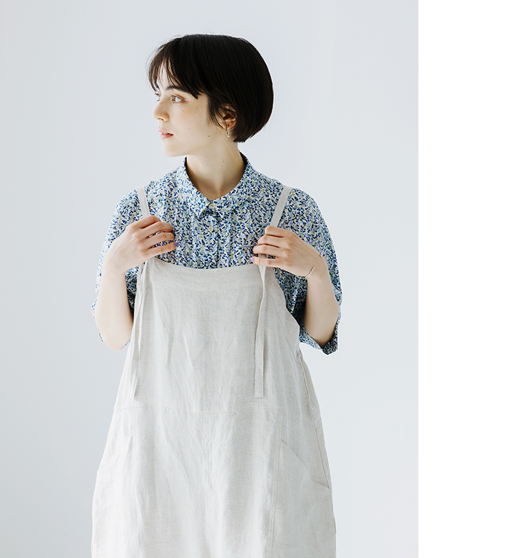 &yarn100％リネンバレルサロペット（ナチュラル）の正面アップ画像。花柄のブルーシャツを合わせた着用カットで、軽やかなリネン素材の質感とナチュラルな風合いを表現。