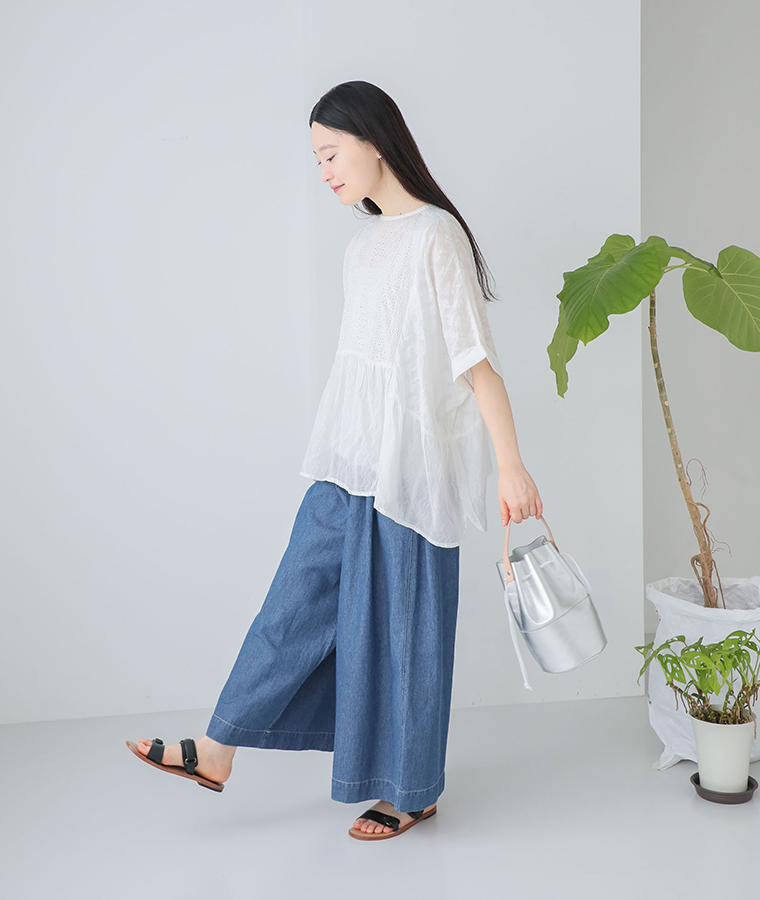 コットン総刺繍パネル切替シャツのアイボリーを着用したモデルの横向き全身画像