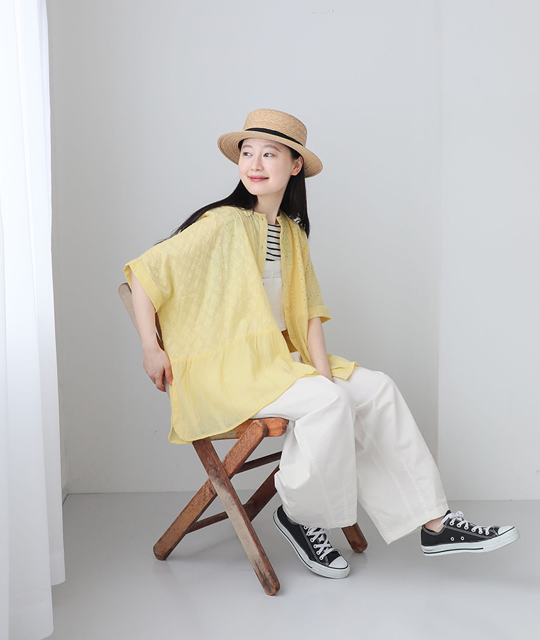 コットン総刺繍パネル切替シャツのイエローを着用したモデルの座り画像