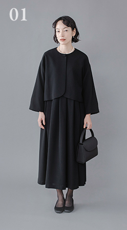 Luuna miu【慶弔両用】大切な日のジャケット＆ワンピースセットの着用イメージ。黒のジャケットとロングワンピースを合わせたフォーマルスタイルで、モデルがグレー背景の前に立ち、黒のハンドバッグを持っている商品画像。