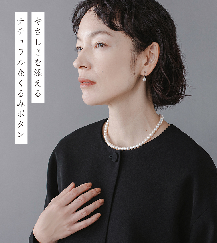Luuna miu【慶弔両用】大切な日のジャケット＆ワンピースセットのディテールイメージ。黒のノーカラージャケットを着たモデルの上半身を横向きに写し、首元のパールネックレスとくるみボタンの質感が際立つ。左側には「やさしさを添える ナチュラルなくるみボタン」という日本語テキストが添えられた商品画像。