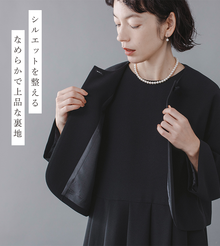Luuna miu【慶弔両用】大切な日のジャケット＆ワンピースセットのディテールイメージ。黒のノーカラージャケットを着たモデルが前を軽く開き、内側のなめらかな裏地を見せている。首元にはパールネックレスを合わせ、左側には「シルエットを整える なめらかで上品な裏地」という日本語テキストが添えられた商品画像。