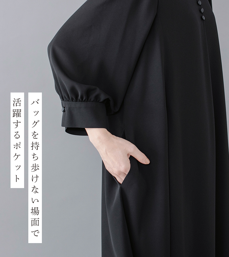 Luuna miu【慶弔両用】大切な日のボタンフレアワンピースのディテールイメージ。黒のワンピースを着たモデルが片手をポケットに入れ、ふんわりとした袖とカフスのくるみボタンが上品に映える。左側には「バッグを持ち歩けない場面で 活躍するポケット」という日本語テキストが添えられた商品画像。
