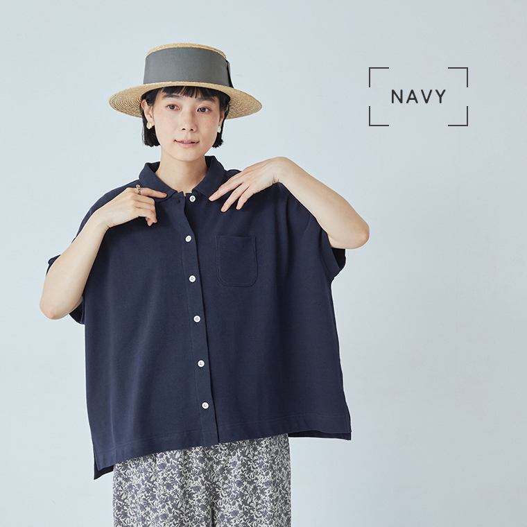 ネイビーの2wayポロを着用した女性モデルの座りスタイル