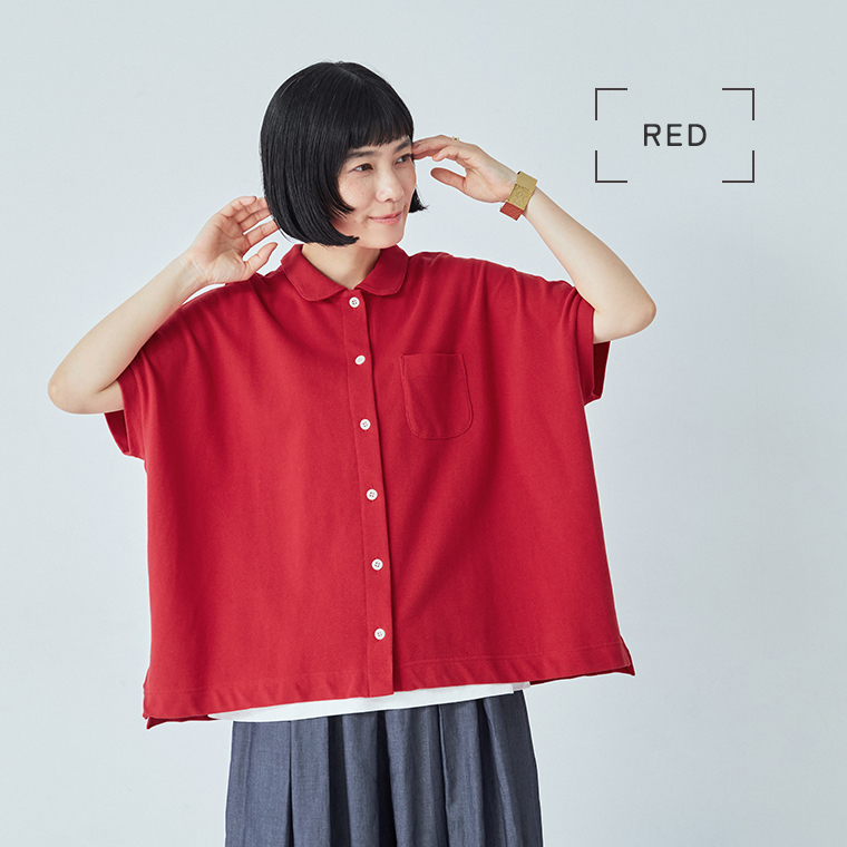 レッドの2wayポロを着用した女性モデルの座りスタイル