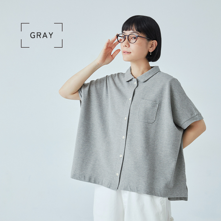 グレーの2wayポロを着用した女性モデルの座りスタイル