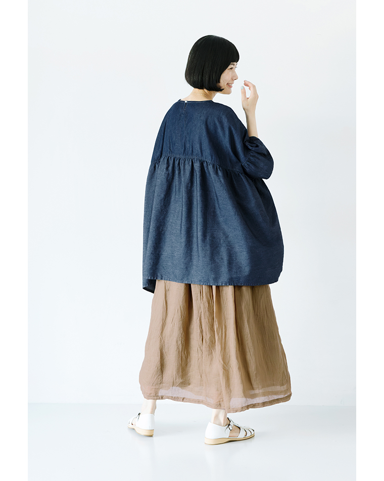 Sorte cuffぜいたくギャザーワイドブラウス（インディゴ）を着用した女性の後ろ姿コーディネート。ふんわりと広がるギャザーとゆったりとしたバックシルエットが特徴で、軽やかな素材感が際立つ商品画像。