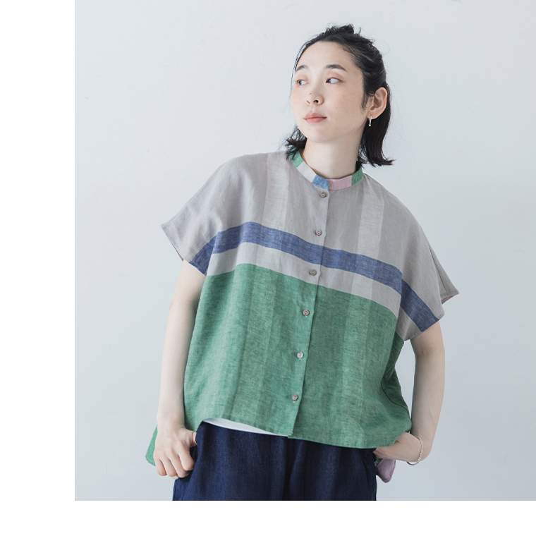 グレーのパネルチェックシャツを着用した女性モデルの上半身スタイル