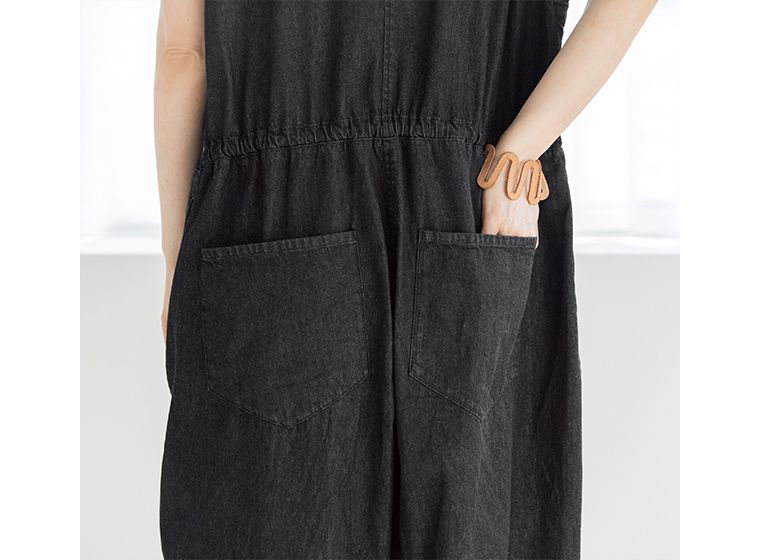 &yarn 滝口和代さんコラボ　or frill all in oneのバックポケットディテール。黒のオールインワンの後ろに大きめのポケットが2つ配置され、実用的でリラックス感のあるデザイン。素材の質感と縫製ラインが際立つアップ画像。
