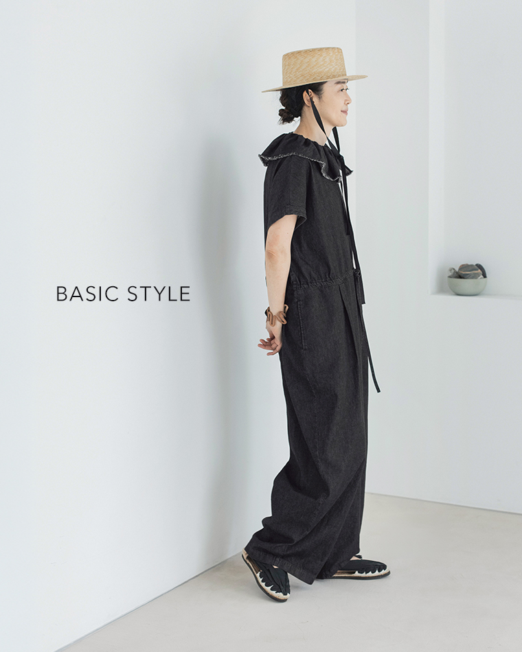 &yarn 滝口和代さんコラボ　or frill all in oneを着用したイメージ。黒のフリル付きオールインワンに麦わら帽子を合わせたベーシックスタイル。横向きのシルエットから、軽やかな素材感とナチュラルな雰囲気が伝わる商品画像。