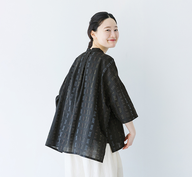 ステッチ刺繍入りローンふわっとシャツを後ろから写したモデル画像