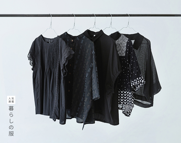 暮らしの服　ブラックカラーのトップスを並べて吊るした画像