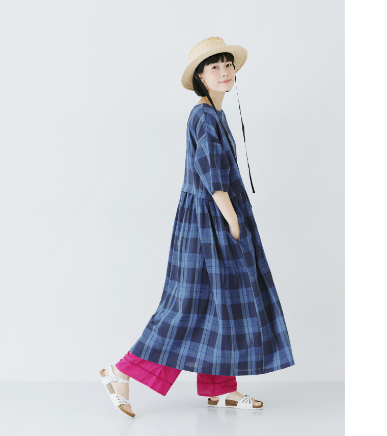 ビッグチェック柄ワンピースにピンクのペチパンツを合わせた女性モデルのサイドスタイル