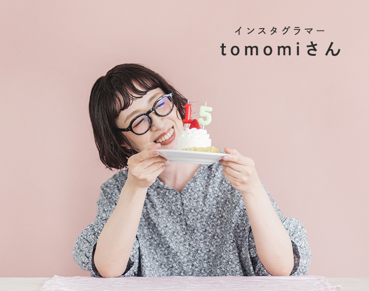着るたびときめく花柄ブラウス ネグレーを着用したモデルがケーキを持っている上半身画像