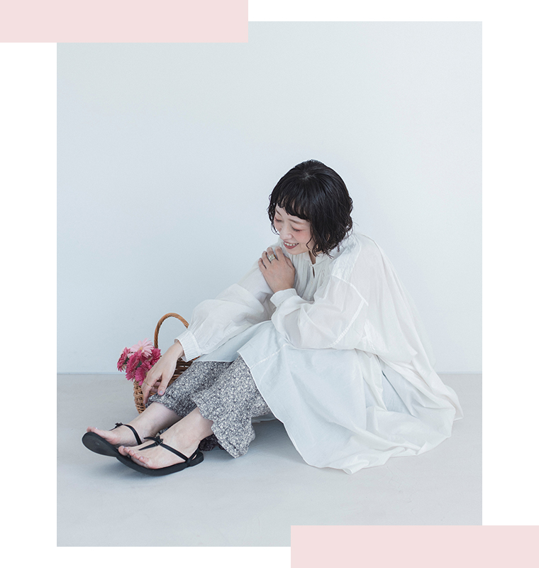 着るたびときめく花柄パンツ グレーを着用したモデルの座り姿画像
