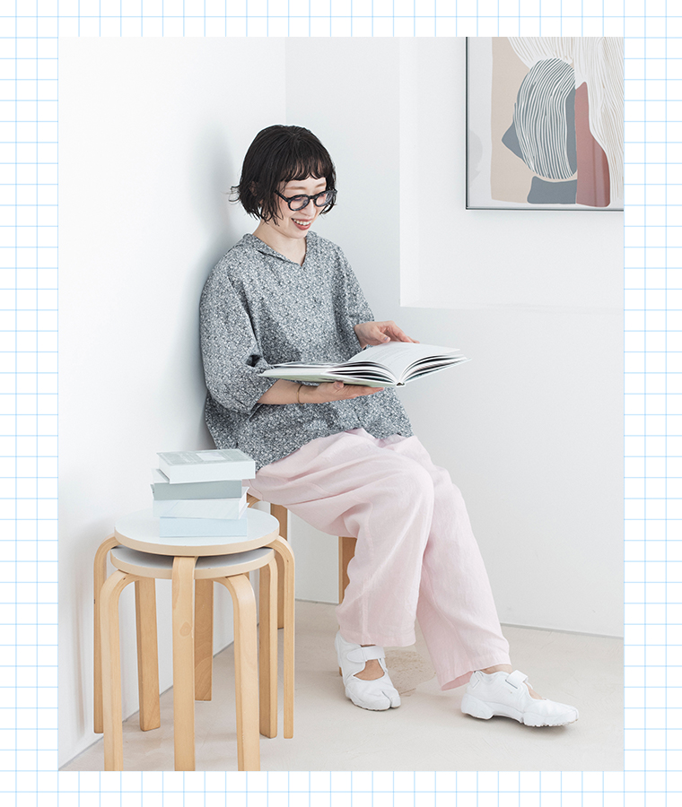 着るたびときめく花柄ブラウス グレーを着用したモデルの座り画像