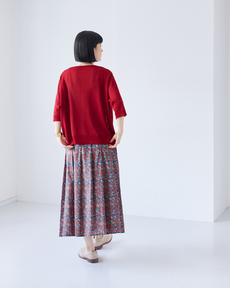 &yarn5分袖ニットカーディガン（レッド）に花柄のロングスカートを合わせた、後ろ姿の全身コーディネート画像