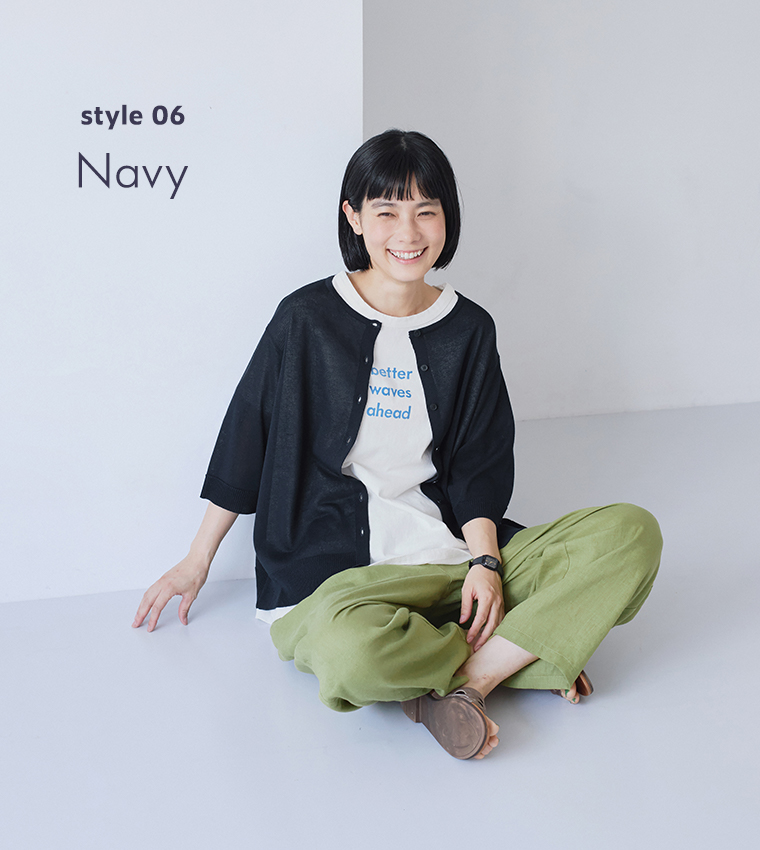&yarn5分袖ニットカーディガン（ネイビー）を前開きで羽織り、ロゴTシャツと黄緑色のワイドパンツを合わせて床に座ったモデルの正面コーディネート（style 06）