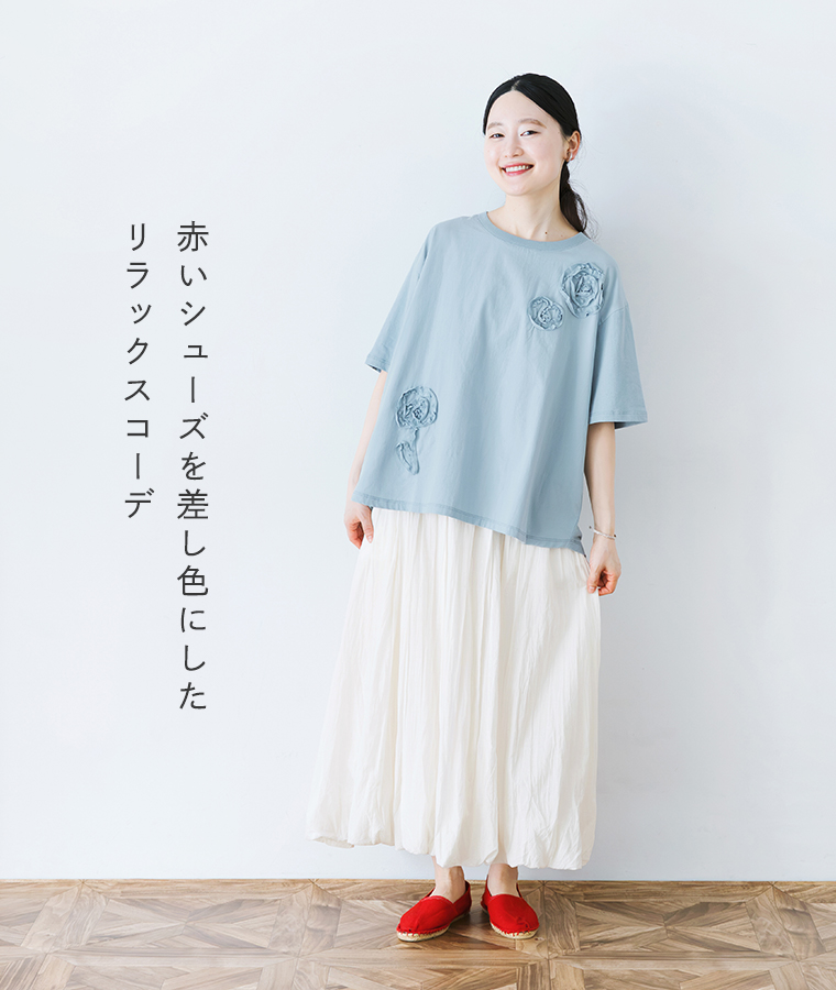 前身布帛立体フラワー刺繍Tシャツをスカートと合わせて着用したモデルの全身画像