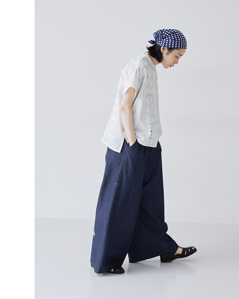 nop de nod コットンスタンドカラーバテンレースシャツ（ホワイト）に、ワイドデニムパンツを合わせたモデルの横姿・全身コーディネート画像。うつむき加減でポケットに手を入れているポーズです。