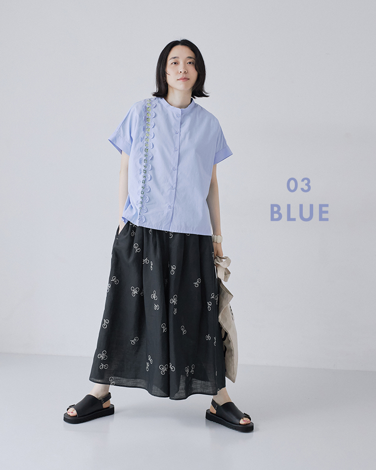 nop de nod コットンスタンドカラーバテンレースシャツ（ブルー）に、刺繍入りの黒いボリュームスカートとサンダルを合わせた正面の全身コーディネート画像。「03 BLUE」のテキスト入りです