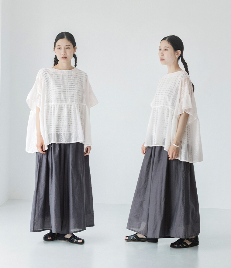 ホワイトのシアー刺繍プルオーバーにボリュームパンツを合わせた女性モデルの全身スタイル