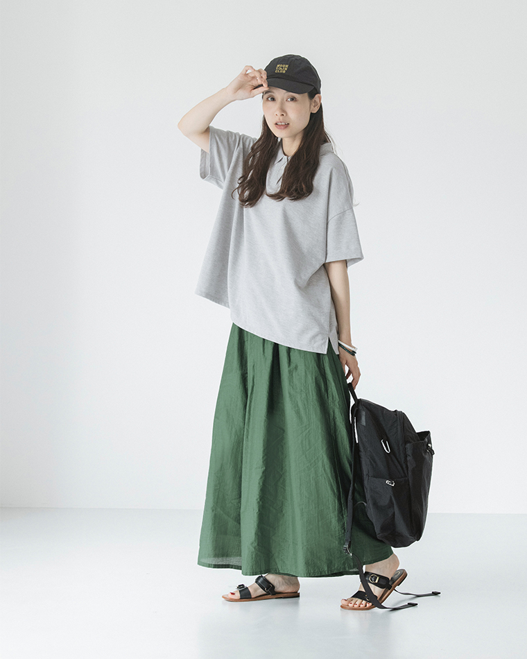 &yarn真夏のシアーフレアワイドパンツ（グリーン）にグレーの半袖ポロシャツ、黒のキャップ、リュック、サンダルを合わせた正面のコーディネート画像