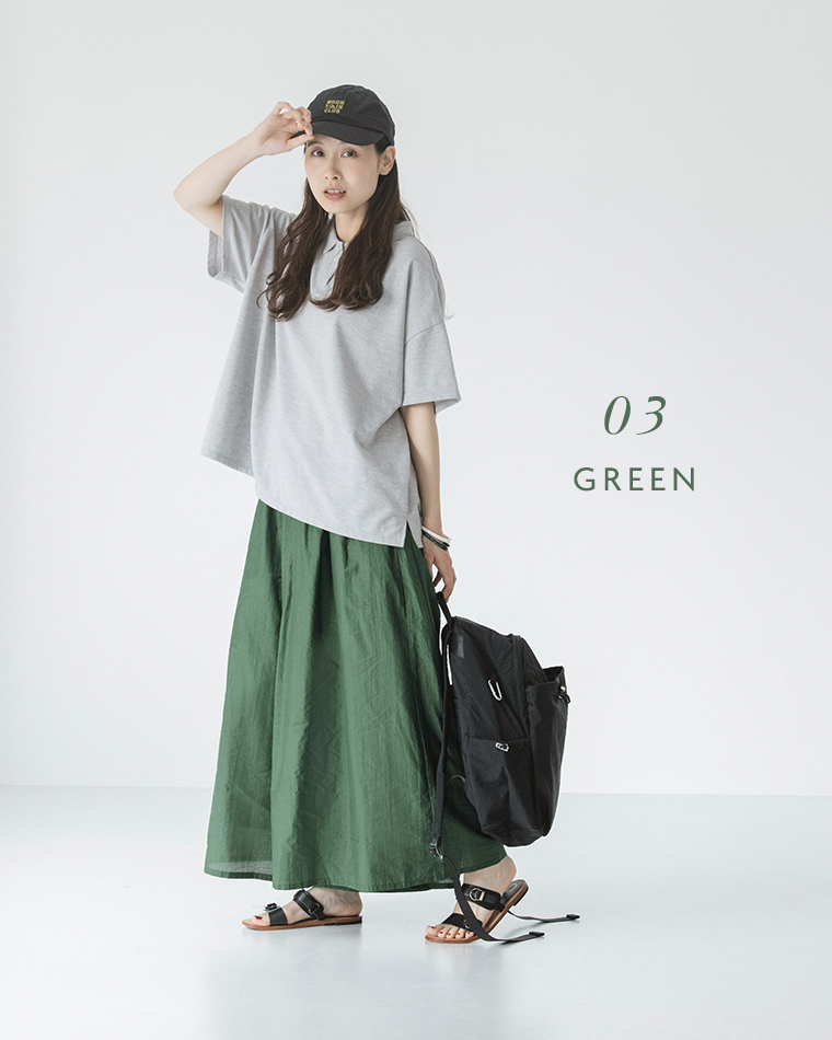&yarn真夏のシアーフレアワイドパンツ（グリーン）にグレーの半袖ニット、キャップ、黒のリュックとサンダルを合わせたカジュアルコーディネート