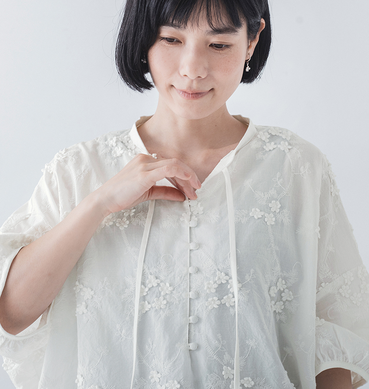Lintu Laulu立体フラワー刺繍ブラウス（オフホワイト）の花刺しゅうとリボンディテールのアップ