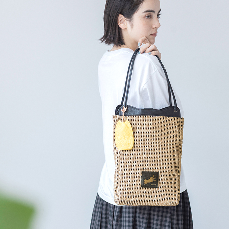 aoneco キーカバーを付けた ラティストートをもつ女性モデルの上半身寄り