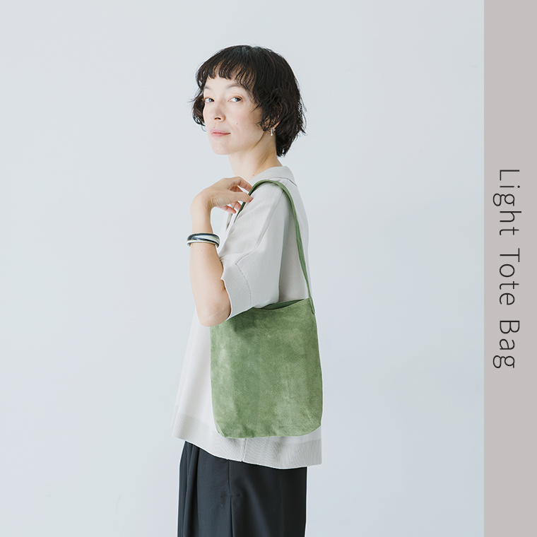 TOKYO LEATHER FACTORY 洗えるピッグスエード ライトトートバッグ（グリーン）を肩掛けした女性モデルの上半身スタイル